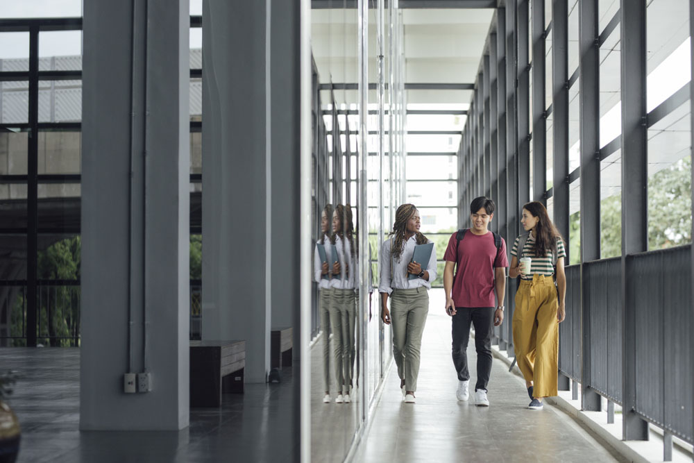 Three university students walking together on campus