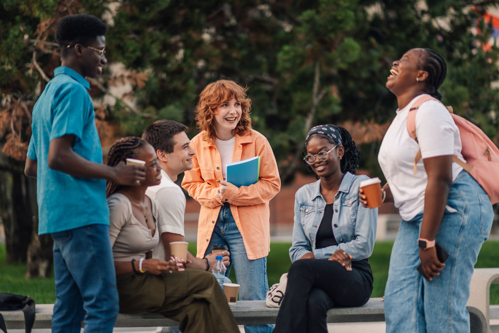 Group of college students with ADHD socializing on campus lawn